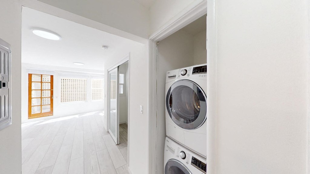 a white laundry room with a washing machine and a dryer
