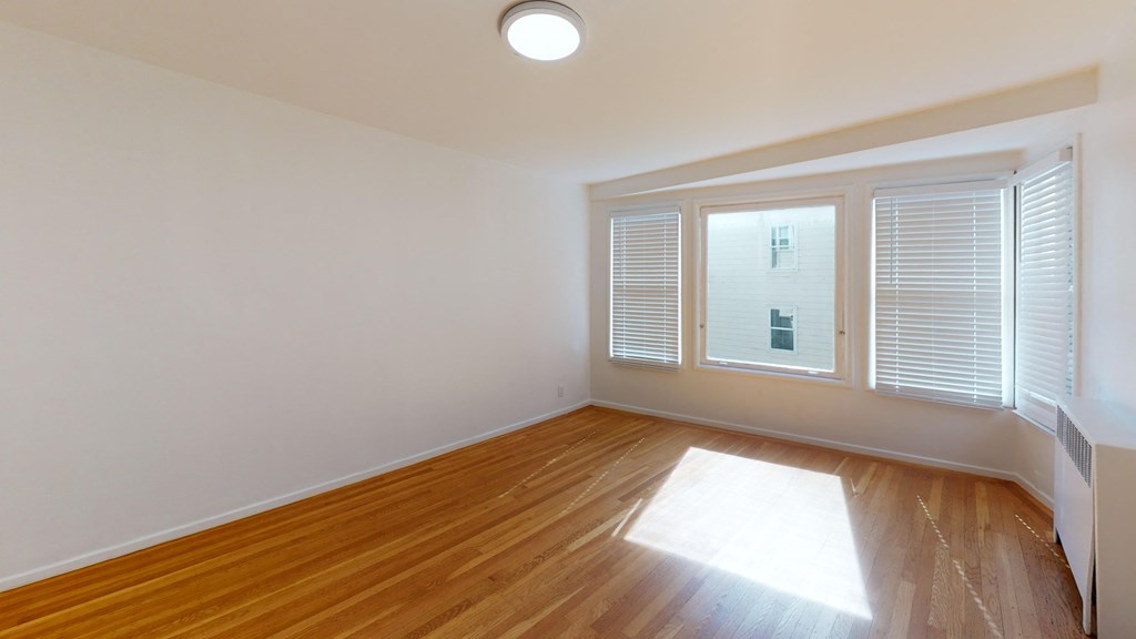 a living room with wood floors and a large window