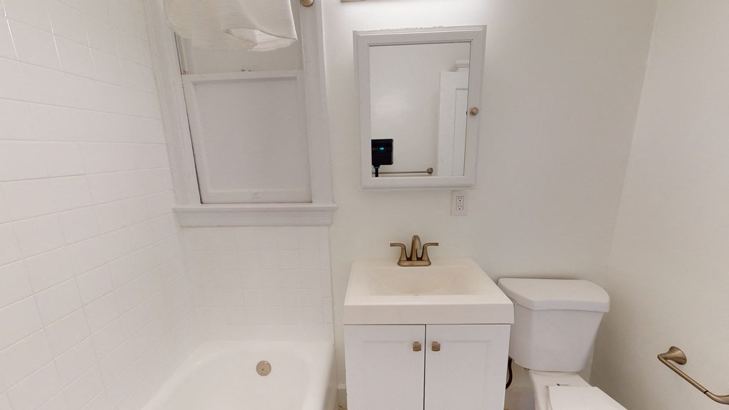 a bathroom with a sink toilet and a mirror