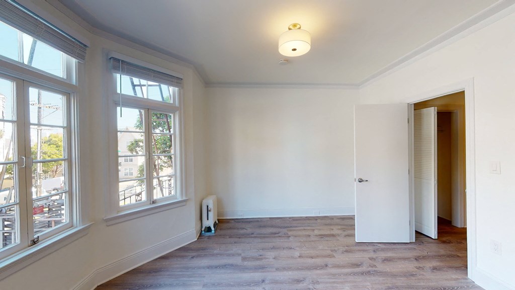 a living room with white walls and large windows