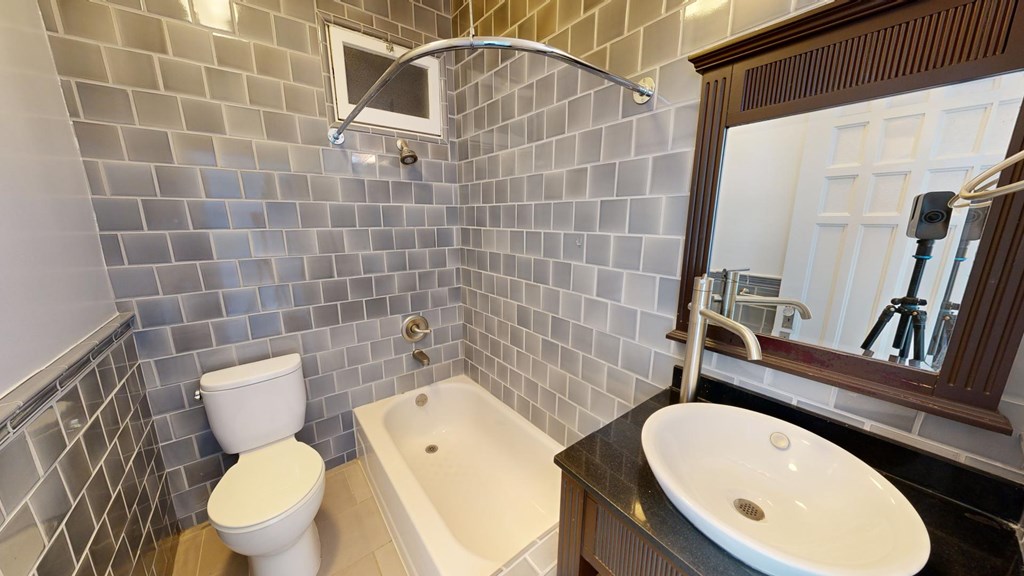 A bathroom with a toilet, sink, and bathtub.