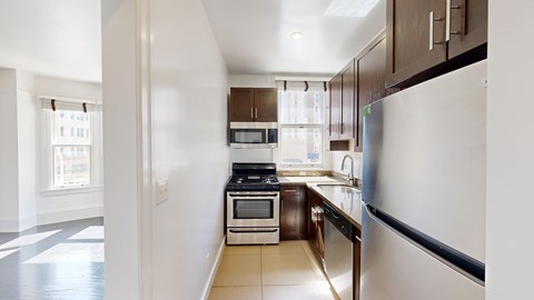 A kitchen with a refrigerator, oven, and microwave.