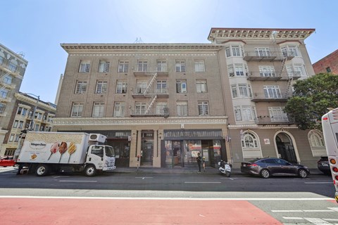 A white truck is parked in front of a building with a bakery.