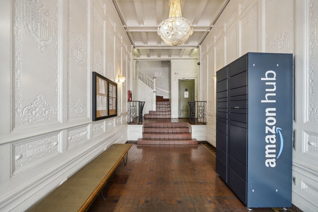Hallway with ornate walls, terracotta tiles, chandelier, bench, stairs, Amazon Hub locker