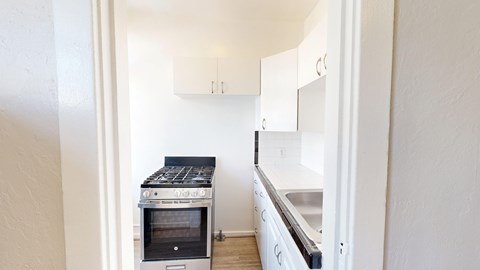 A kitchen with a stove top oven and a sink.