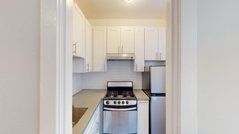 A kitchen with white cabinets and stainless steel appliances.