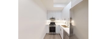 a kitchen with white cabinets and a stove and a sink