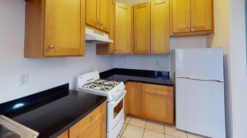 A kitchen with wooden cabinets and a white refrigerator.