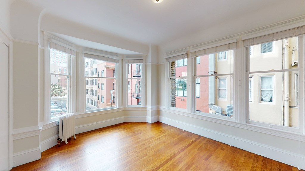 a living room with wood floors and large windows
