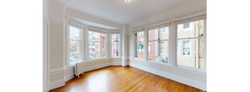 a living room with wood floors and large windows