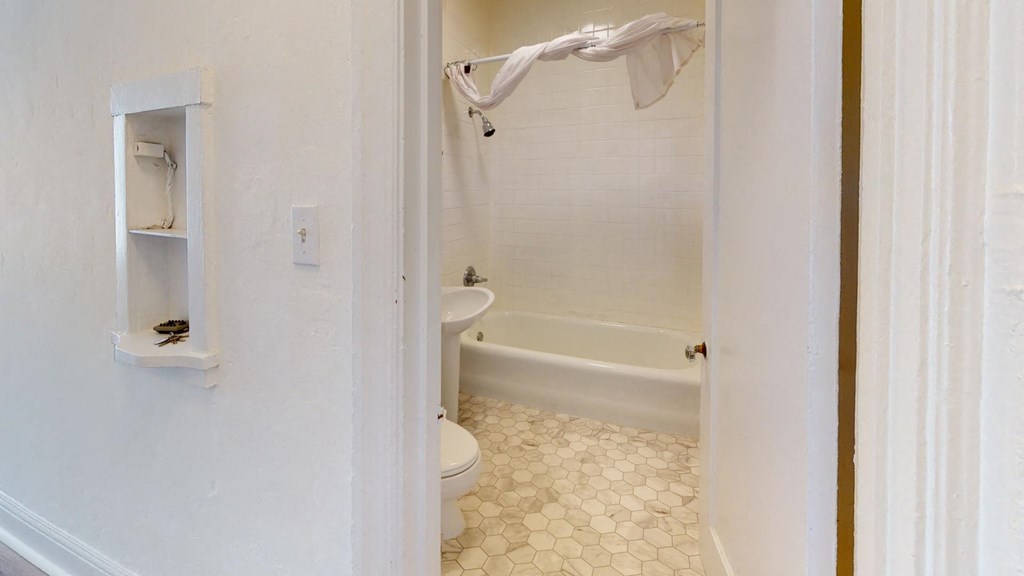 a bathroom with a toilet and a tub and a sink