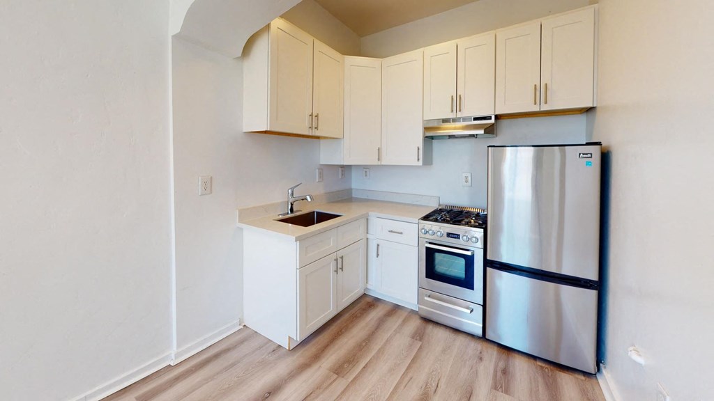 a renovated kitchen with stainless steel appliances and white cabinets
