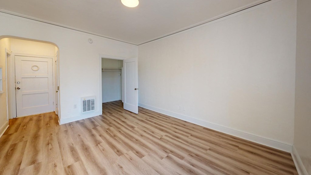 a living room with white walls and wood floors