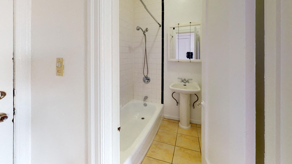 a white bathroom with a tub and a sink