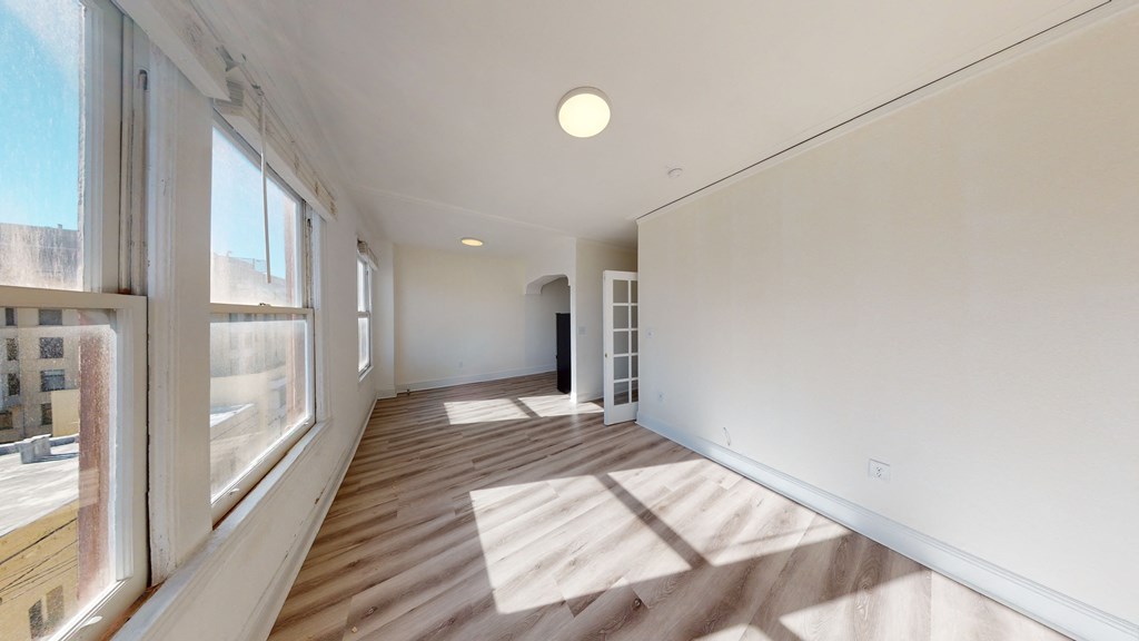 a living room with wood floors and a large window