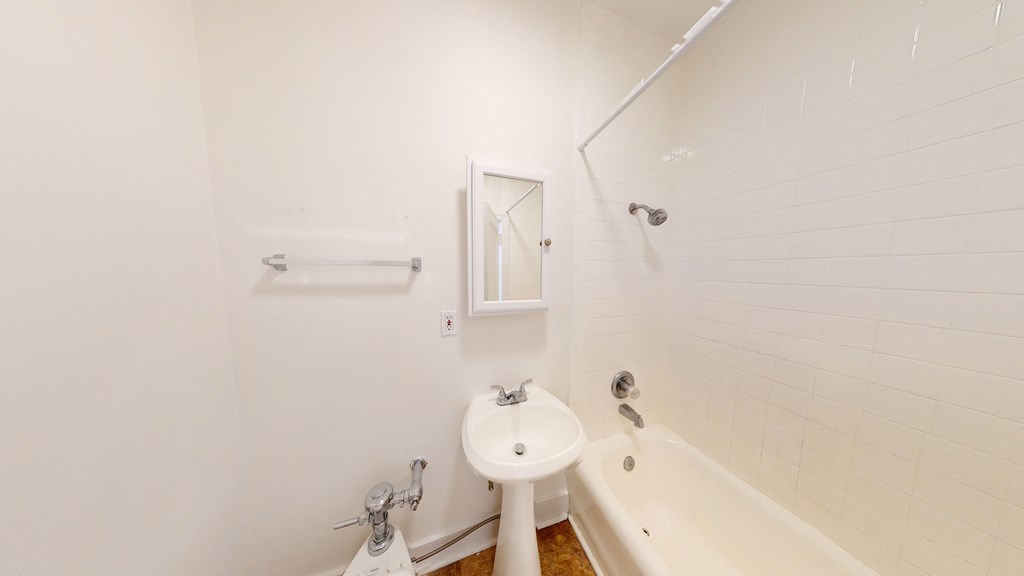 a white bathroom with a sink and a tub