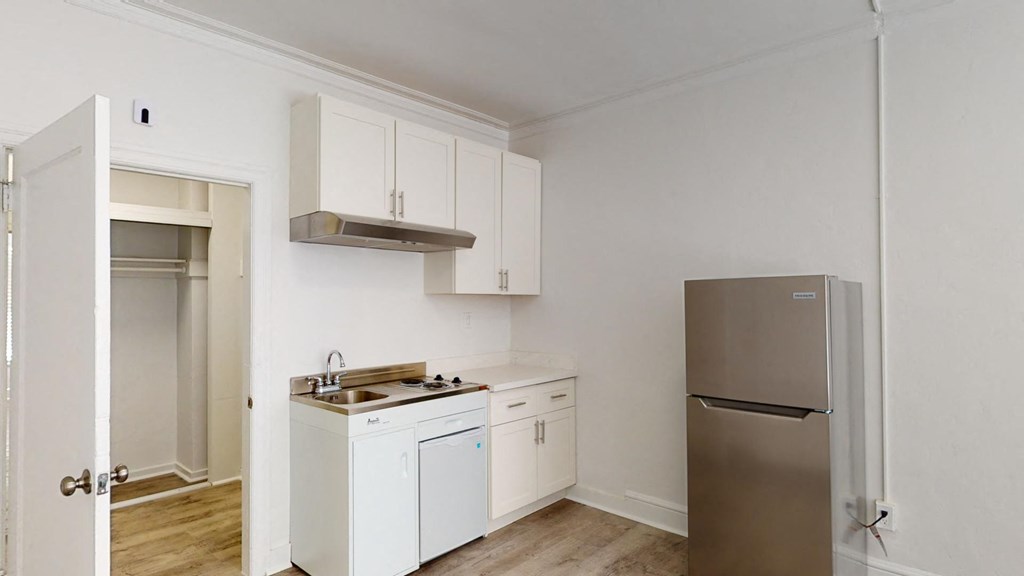 a kitchen with white cabinets and a stainless steel refrigerator