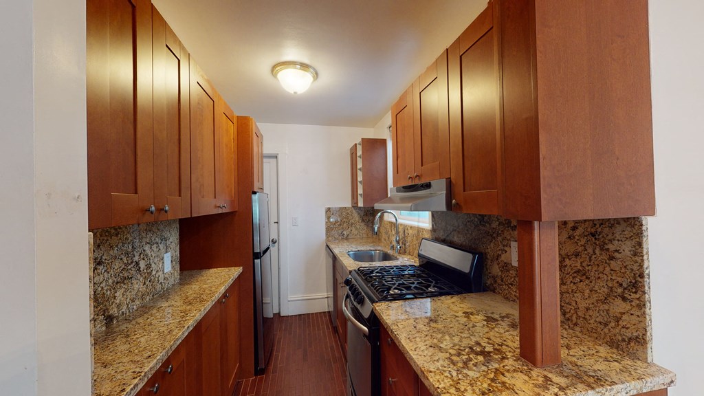 a kitchen with granite counter tops and wooden cabinets