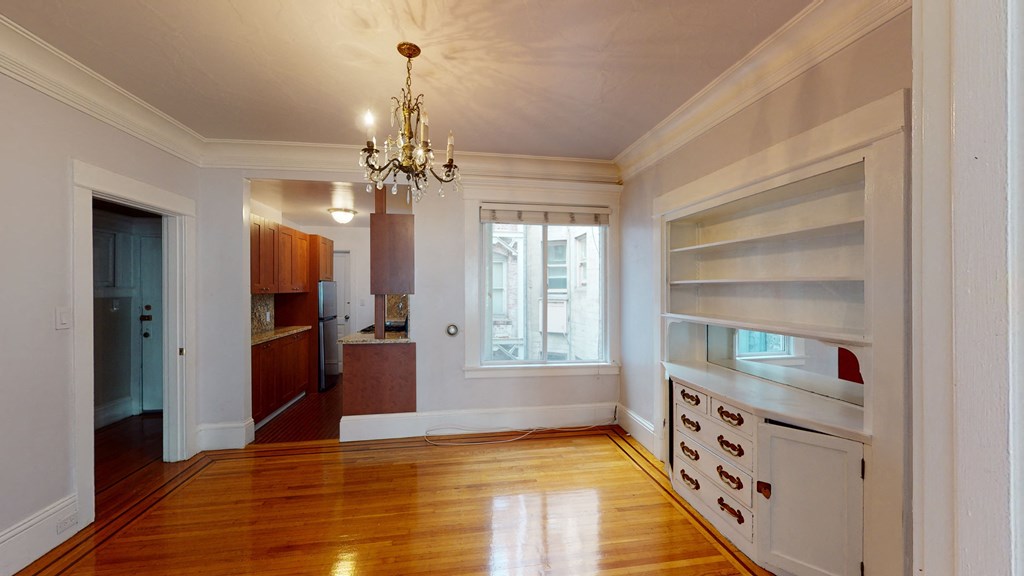 a living room with a hard wood floor and a chandelier