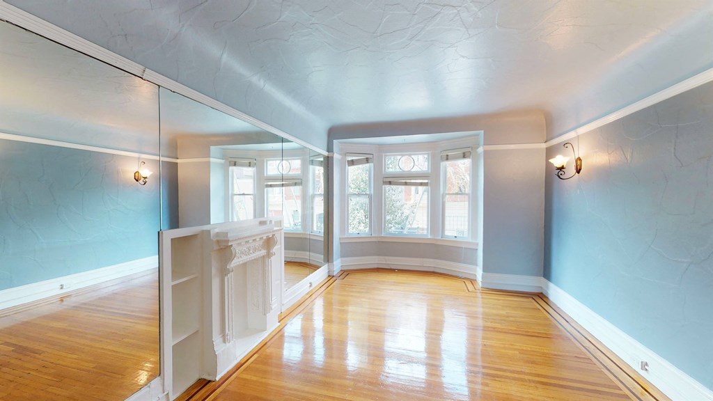 an empty living room with blue walls and a wood floor