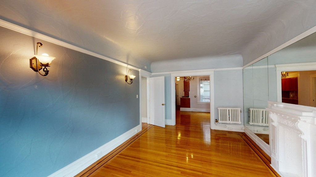 a living room with blue walls and a hard wood floor