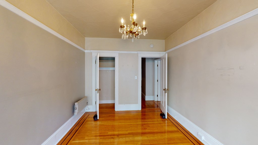 a living room with a hard wood floor and a chandelier