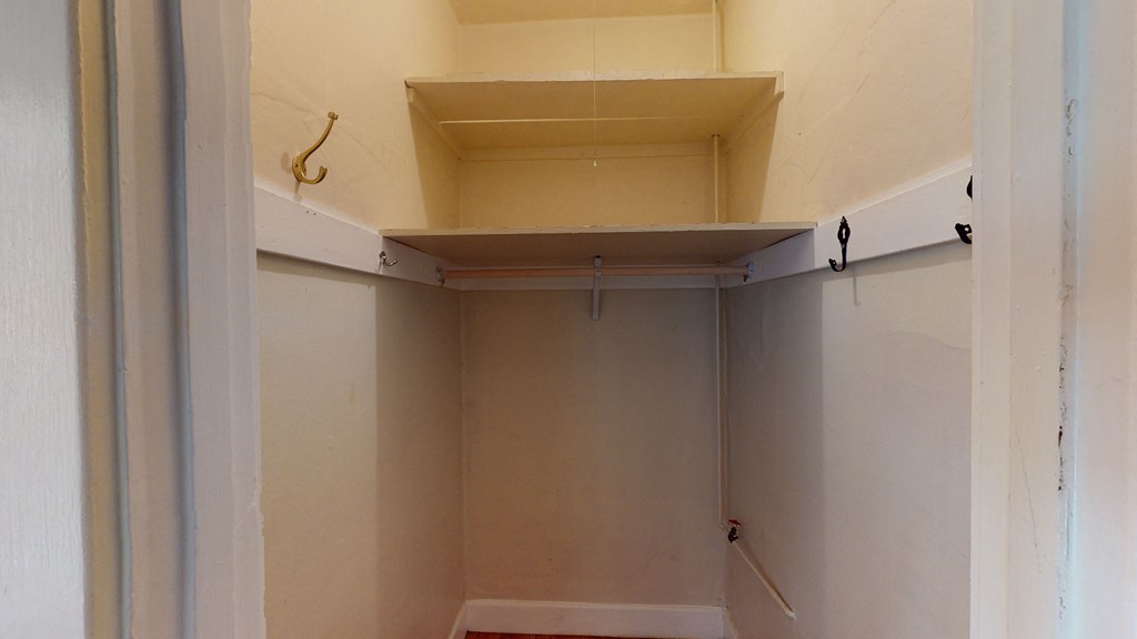 an empty closet in a bathroom with a shelf