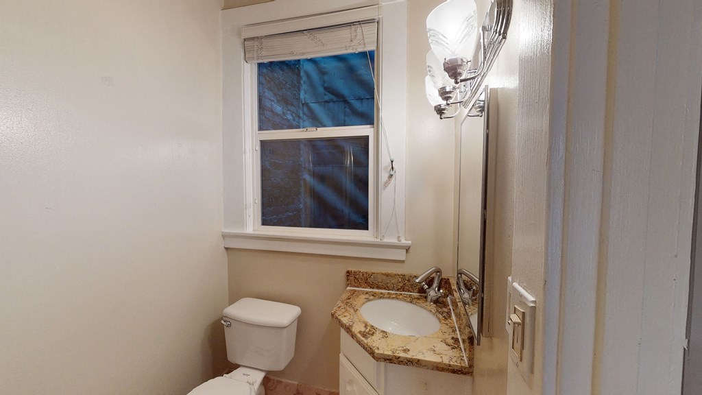 a bathroom with a toilet and a sink and a window