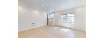 an empty living room with white walls and wood floors