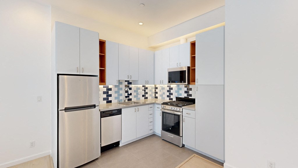 a kitchen with white cabinets and stainless steel appliances