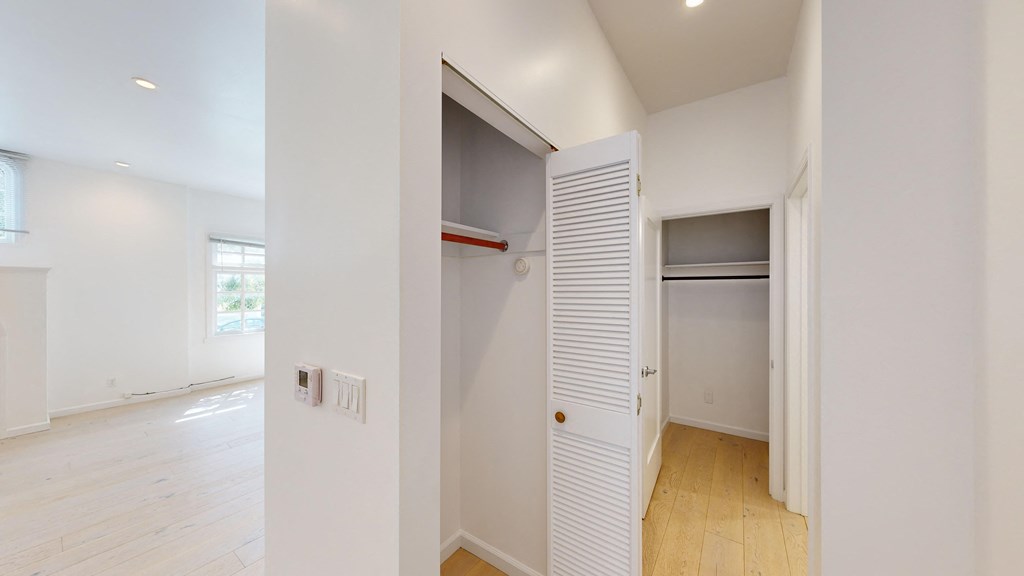 an empty room with white walls and a closet with a door