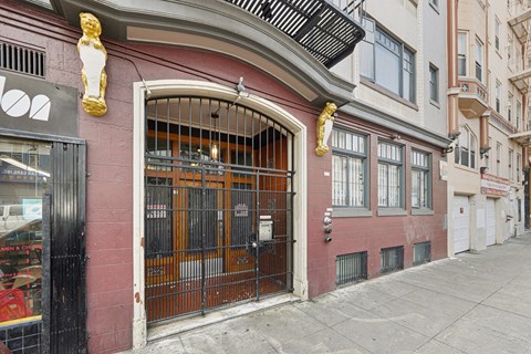 A red building with a black gate and a window with bars.