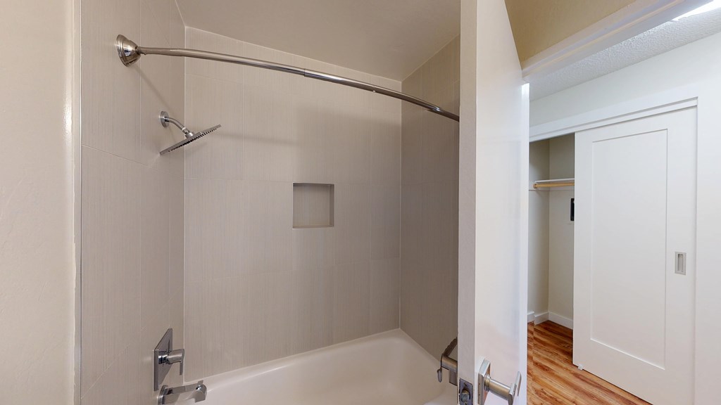 A white bathroom with a glass shower door.