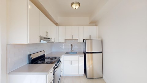 A kitchen with white cabinets and appliances.