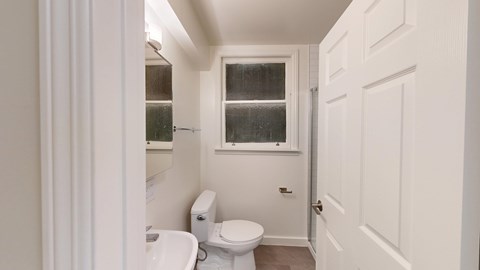 A white toilet and sink in a small bathroom.