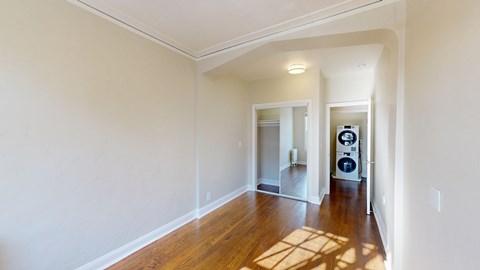 A room with a white wall and a wooden floor.