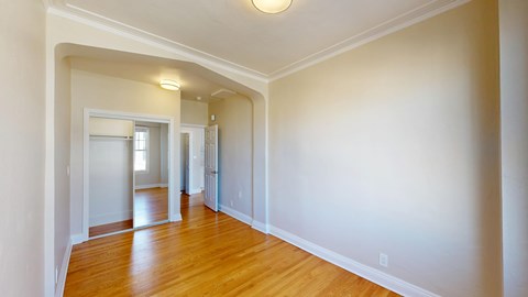 A long hallway with wood floors and white walls.