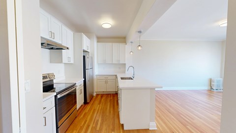 A kitchen with white appliances and wooden floors.