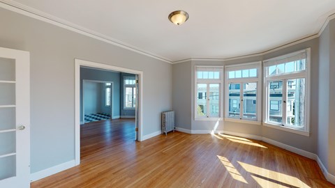 A room with wooden floors and a large window.