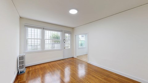 A room with a white wall and a wooden floor.