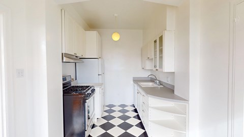 A black and white checkered floor in a white kitchen.