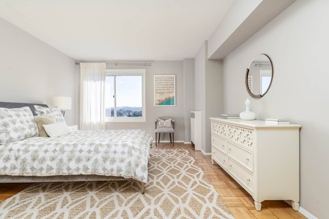 A bedroom with a large bed and a dresser.