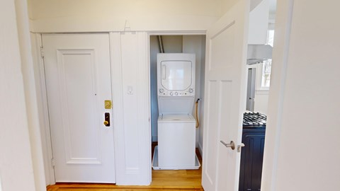 A white door is open to a small kitchen.