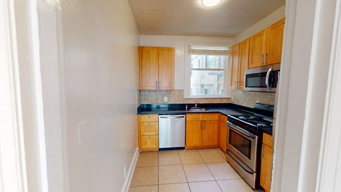 A kitchen with wooden cabinets and a tiled backsplash.