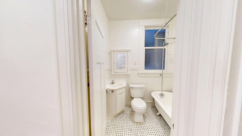 A white bathroom with a toilet, sink, and bathtub.
