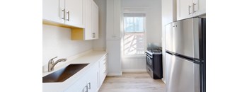 a kitchen with white cabinets and stainless steel appliances