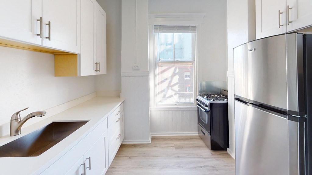 a kitchen with white cabinets and stainless steel appliances