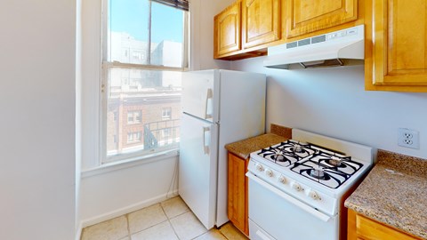 A kitchen with a white fridge and a white gas stove.