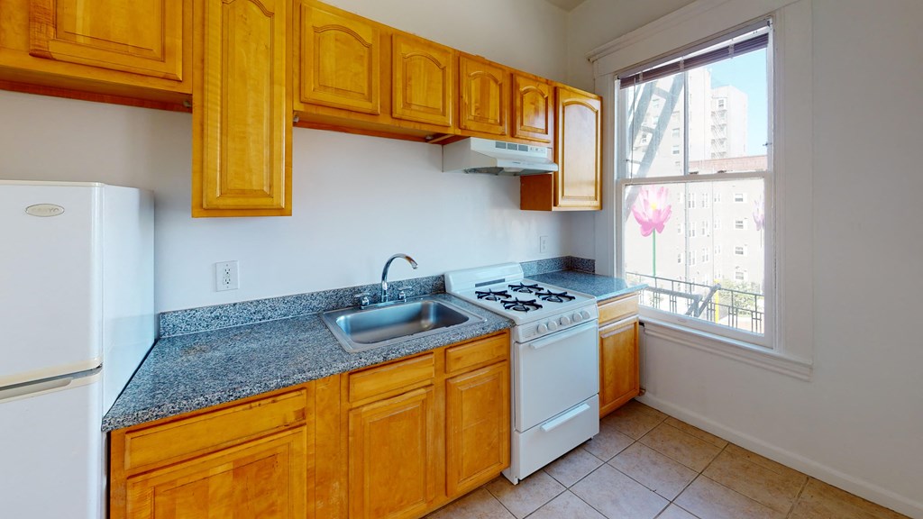 a kitchen with wooden cabinets and a sink and a window