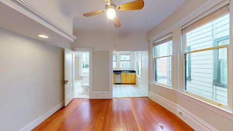 A room with wooden floors and a ceiling fan.
